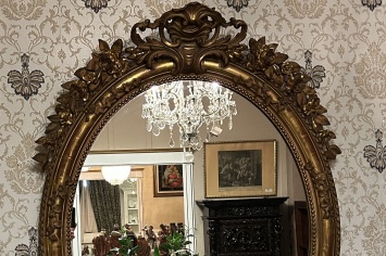 GIANT ANTIQUE GOLD LEAF MIRROR WITH HIGH RELIEF IN AN OVAL SHAPED DESIGN