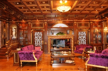 CLASSIC LIVING ROOM WITH PANELING ON THE WALLS AS WELL AS COFFERED CEILING AND LINED FIREPLACE